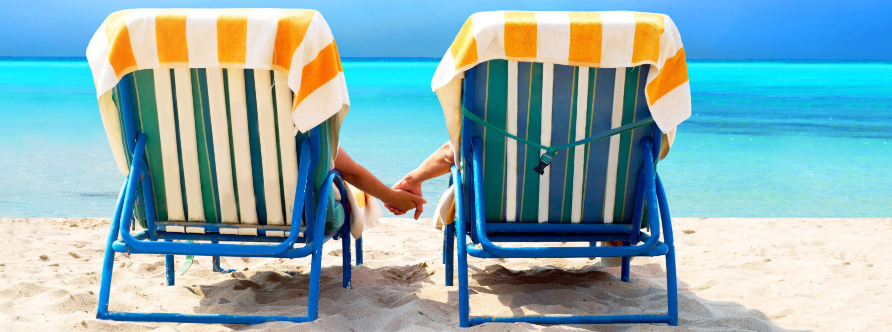Two beach chairs facing ocean depiction vacation on beach