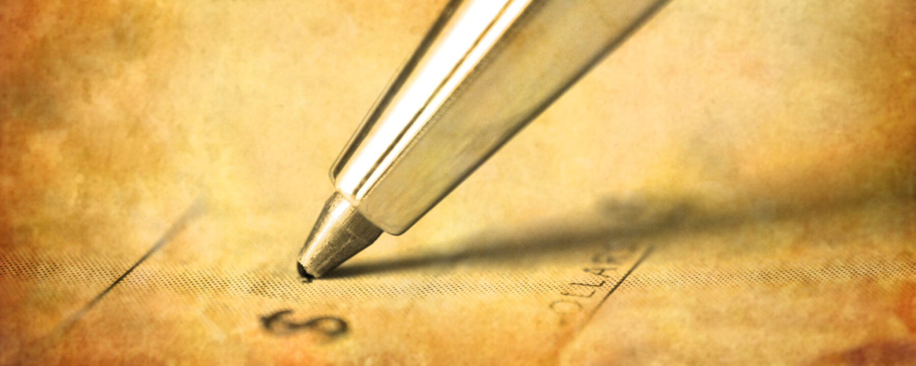 Close up photo of ink pen writing a check